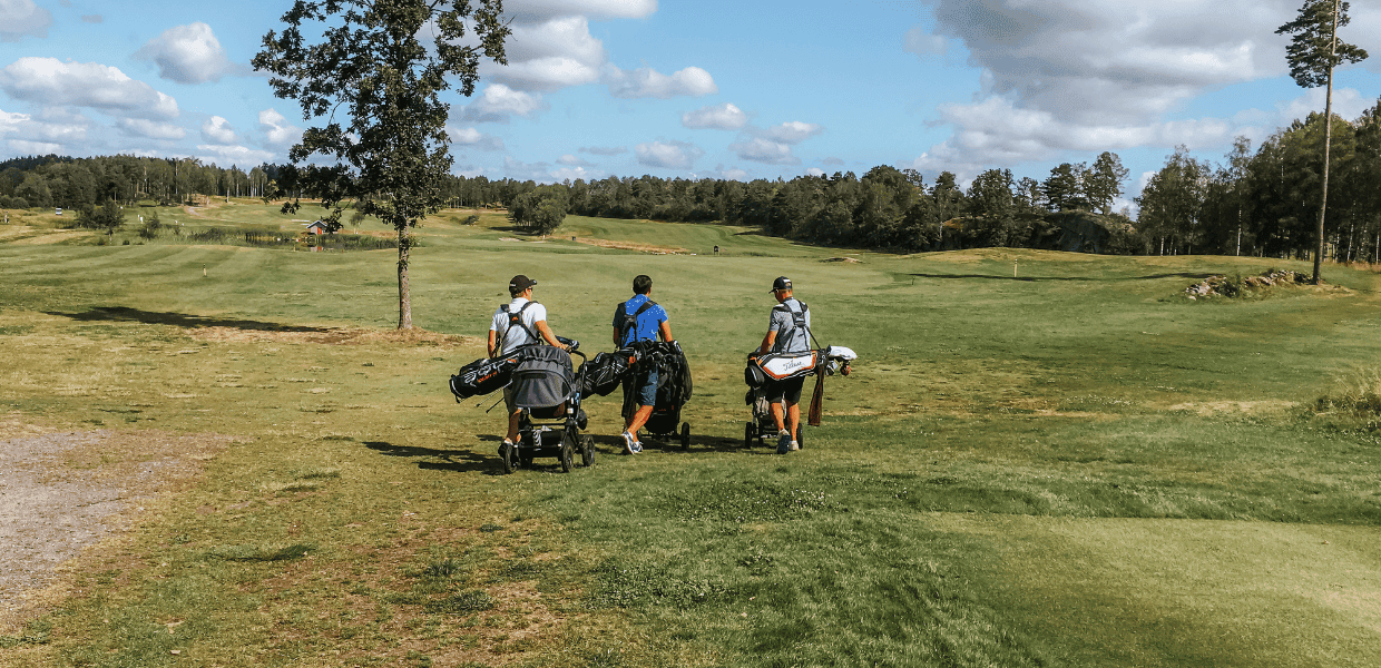 tre personer på golfbane
