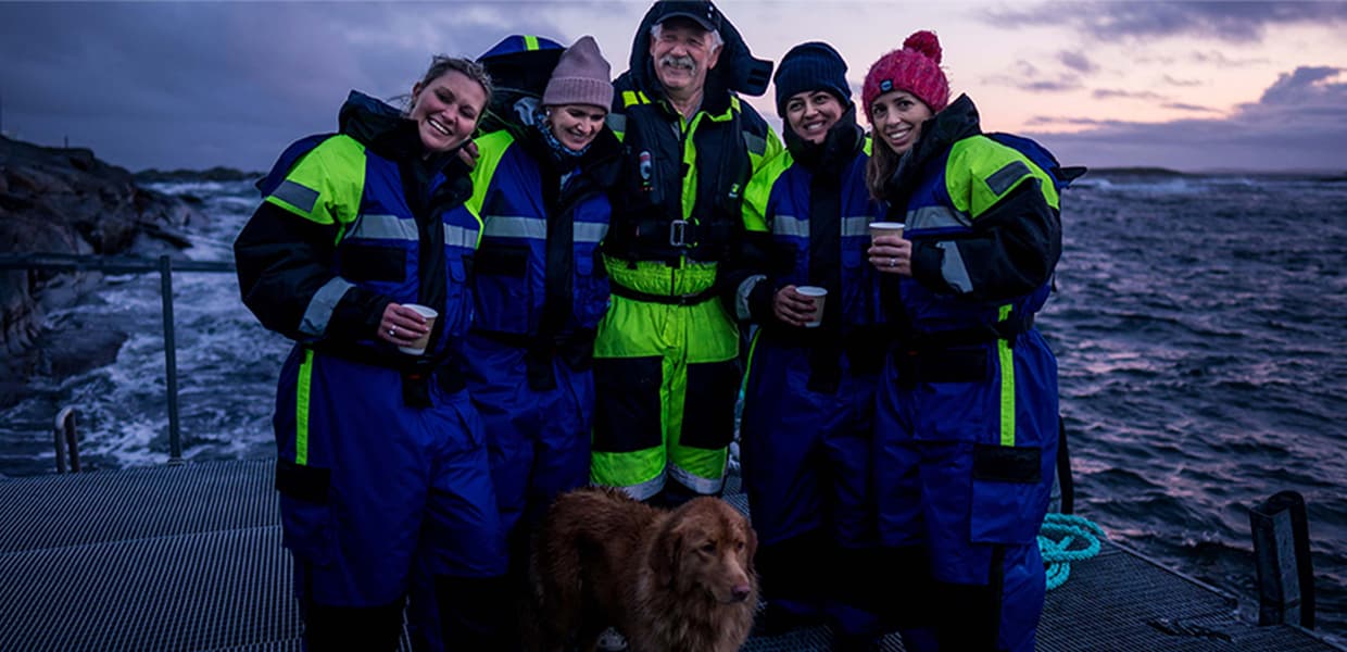Gruppe med mennesker på brygge ved sjøen